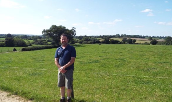 Kenton Bennett standing in front of fields at Perry Farm